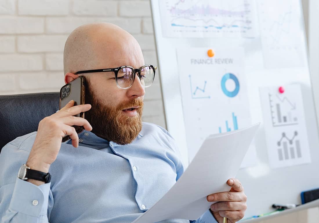 Man on Phone with Papers in his Hand